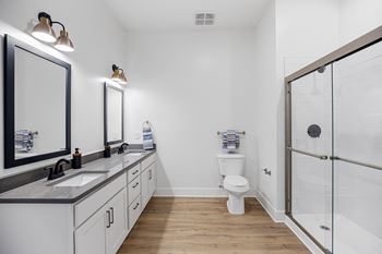 a white bathroom with a shower and a sink and a toiletat Oak Grove at Blake Farm, Wilmington, North Carolina